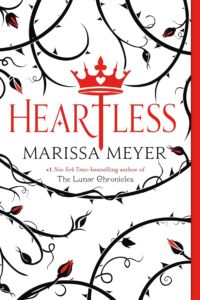 white book cover with black stylized vines and leaves across it with the title Heartless in red with a a crown graphic on the top of the